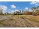 View of an empty lot with sparse grass and trees at 1665 Manor Rd, Englewood, FL 34223