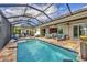 Inviting pool area with covered lanai, comfortable seating, and lush landscaping at 17 Par View Pl, Rotonda West, FL 33947