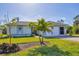 One-story home with attached garage,palm trees, and landscaped lawn at 185 Cougar Way, Rotonda West, FL 33947