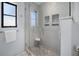 Modern bathroom with a large glass shower, pebble floor, and built-in shelves at 1954 Arkansas Ave, Englewood, FL 34224