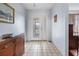 Bright entryway with tiled floor, wooden console table, and access to other rooms at 1954 Arkansas Ave, Englewood, FL 34224