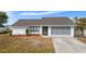 White single-story home with gray screened garage and landscaping at 1954 Arkansas Ave, Englewood, FL 34224