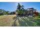 Large backyard showcasing a home with a screened patio and tropical landscaping at 21228 Sandal Foot Dr, Venice, FL 34293