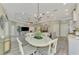 Open concept dining area with white table and chairs, adjacent to kitchen at 21228 Sandal Foot Dr, Venice, FL 34293