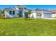 White two-story house with a three-car garage and manicured lawn at 22 Windward Rd, Placida, FL 33946