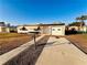 Front view of a ranch home with a yard and driveway at 22326 Midway Blvd, Port Charlotte, FL 33952