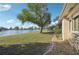 Large backyard with lake view, lush grass, and mature trees at 2365 Malaya Ct, Punta Gorda, FL 33983