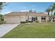 Tan house with a stone accent, screened entry, and landscaped lawn at 2365 Malaya Ct, Punta Gorda, FL 33983