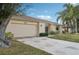 Tan house with a large garage door and a stone-accented front at 2365 Malaya Ct, Punta Gorda, FL 33983