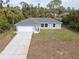 New construction home with a large yard and driveway at 2462 Ensenada Ln, North Port, FL 34286