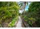 Landscaped backyard with lush tropical plants and a winding stone path at 26266 Barcelos Ct, Punta Gorda, FL 33983