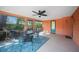 Bright screened porch with ceiling fan and outdoor seating at 272 Cedar St, Englewood, FL 34223