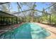 Refreshing kidney-shaped pool with screened enclosure at 272 Cedar St, Englewood, FL 34223