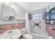 Bathroom with pink tile, white tub and shower at 2871 13Th St, Englewood, FL 34224