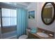 Clean bathroom with tub shower, granite vanity, and beachy decor at 4064 Harbor Blvd, Port Charlotte, FL 33952