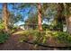 Landscaped backyard with mature trees and a screened porch at 421 Riviera St, Venice, FL 34285