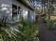 Landscaped side yard with tropical plants leading to the backyard at 421 Riviera St, Venice, FL 34285