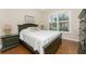 Guest bedroom with dark wood frame bed and hardwood floors at 4370 Turnberry Cir, North Port, FL 34288