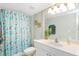 Clean bathroom with seashell shower curtain, white vanity, and mirror at 50 Meredith Dr # 12, Englewood, FL 34223