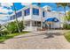 Inviting clubhouse entrance with a paved driveway and lush tropical landscaping at 5000 Gasparilla Rd # 48, Boca Grande, FL 33921