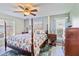 King-size bed, wood furniture, and a ceiling fan in this bedroom at 601 Bramblewood Ln, Englewood, FL 34223