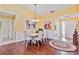 Bright dining room with hardwood floors, chandelier and seating for six at 601 Bramblewood Ln, Englewood, FL 34223