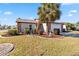 Landscaped front yard with palm tree and stone accents at 601 Bramblewood Ln, Englewood, FL 34223