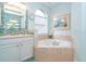 Relaxing bathroom with soaking tub, tile shower, and updated fixtures at 70 Marker Rd, Rotonda West, FL 33947