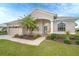 Tan house with a two-car garage and lush landscaping at 70 Marker Rd, Rotonda West, FL 33947