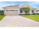 Tan one-story house with a three-car garage and landscaped yard at 70 Marker Rd, Rotonda West, FL 33947