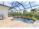 Enclosed pool area with a waterfall feature and brick pavers at 70 Marker Rd, Rotonda West, FL 33947