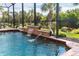 Waterfall feature in a screened-in pool area at 70 Marker Rd, Rotonda West, FL 33947