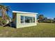 Light green house with large windows and a grassy yard at 701 W Perry St, Englewood, FL 34223