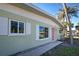 Close-up of house exterior, showcasing light green walls and pink door at 701 W Perry St, Englewood, FL 34223