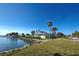 Single story home with waterfront access, palm trees and a manicured lawn at 701 W Perry St, Englewood, FL 34223