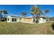 Light green house with wooden boards and a grassy yard at 701 W Perry St, Englewood, FL 34223