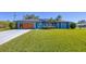 Modern home exterior with wood garage door and landscaping at 7510 Kenway St, Englewood, FL 34224