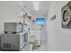 Bright laundry room with washer, dryer, shelving, and microwave at 7510 Kenway St, Englewood, FL 34224