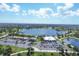 Aerial view of community clubhouse, lake, and parking area at 80 Long Meadow Ln, Rotonda West, FL 33947