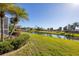 Expansive backyard with a canal view, tropical foliage, and lush lawn at 80 Long Meadow Ln, Rotonda West, FL 33947