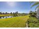 Serene canal view from the backyard with lush grass and tropical landscaping at 80 Long Meadow Ln, Rotonda West, FL 33947