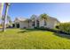 Tan one-story house with palm trees and lush landscaping at 80 Long Meadow Ln, Rotonda West, FL 33947