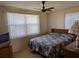 Bedroom with floral bedding, ceiling fan, and window blinds at 839 E 4Th St, Englewood, FL 34223