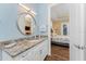 Light and airy bathroom with granite vanity and a large mirror at 9240 Pine Cove Dr, Englewood, FL 34224