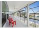 Relaxing screened porch with red chairs and peaceful water views at 9240 Pine Cove Dr, Englewood, FL 34224