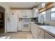 White kitchen with stainless steel appliances and light wood flooring at 93 Boundary Blvd # 301, Rotonda West, FL 33947