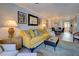 Living room with mustard-colored sofa and view into dining area at 93 Boundary Blvd # 301, Rotonda West, FL 33947