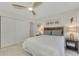 Spacious bedroom with a queen bed, double doors, and wood accent wall at 1 Quails Run Blvd # 5, Englewood, FL 34223