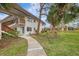 Condo building with walkway leading to the entrance, surrounded by lush landscaping at 1 Quails Run Blvd # 5, Englewood, FL 34223