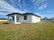 Rear view of house with covered patio and grassy yard at 110 San Antonio Ave, North Port, FL 34287